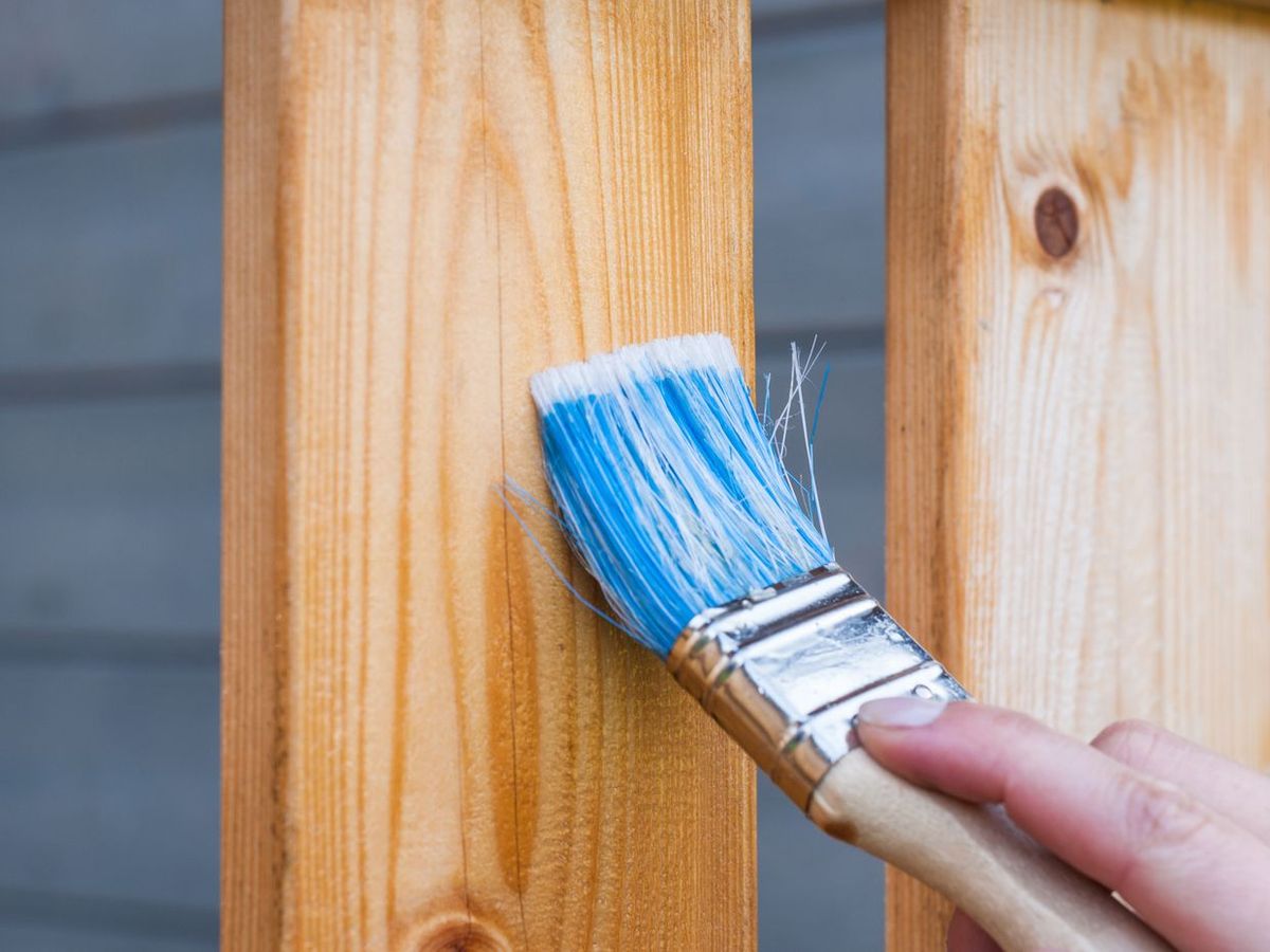 Peinture d'une clôture en bois au pinceau